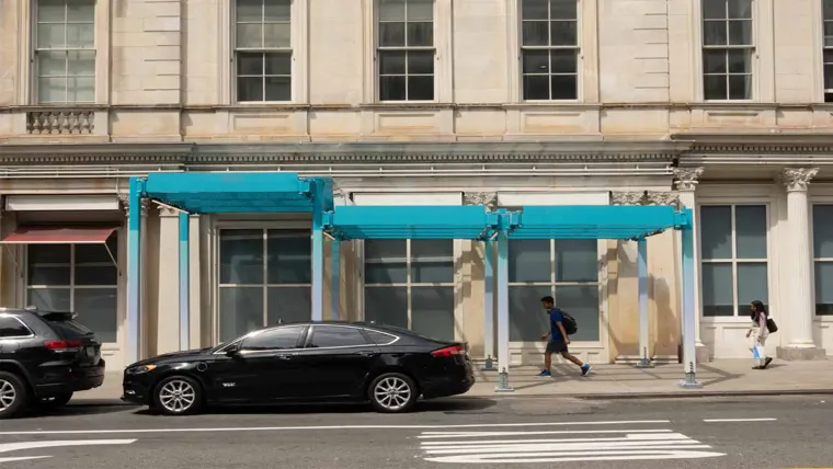 A black car parked in front of a building with a blue shed