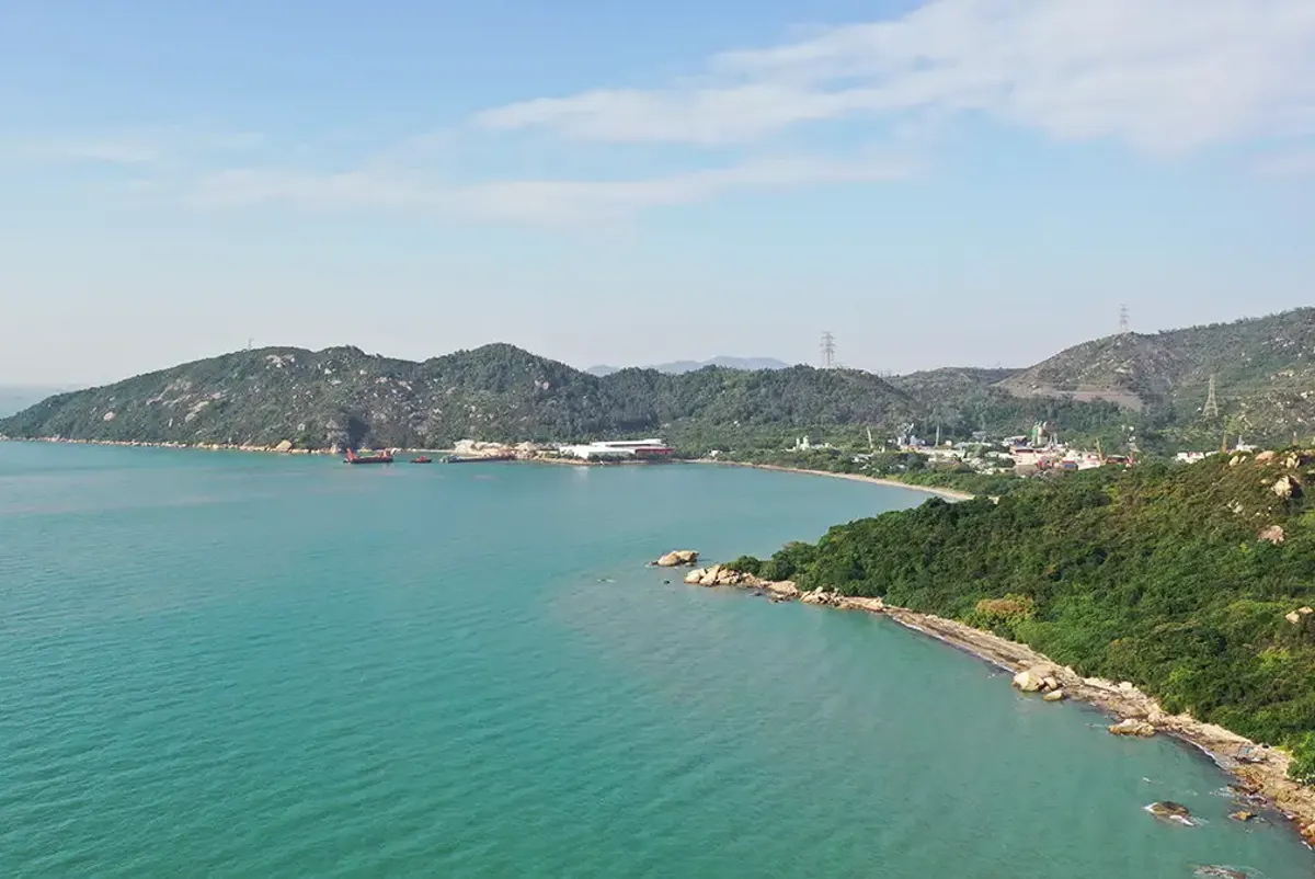 A body of water with land and buildings along it.