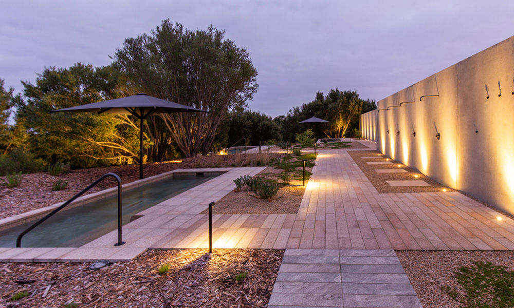 Outdoor pool, paths with wall with mood lighting at dusk