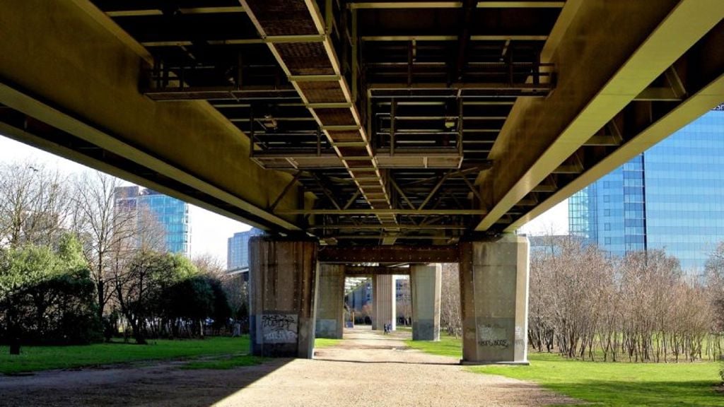 A concrete walkway with a bridge over it.