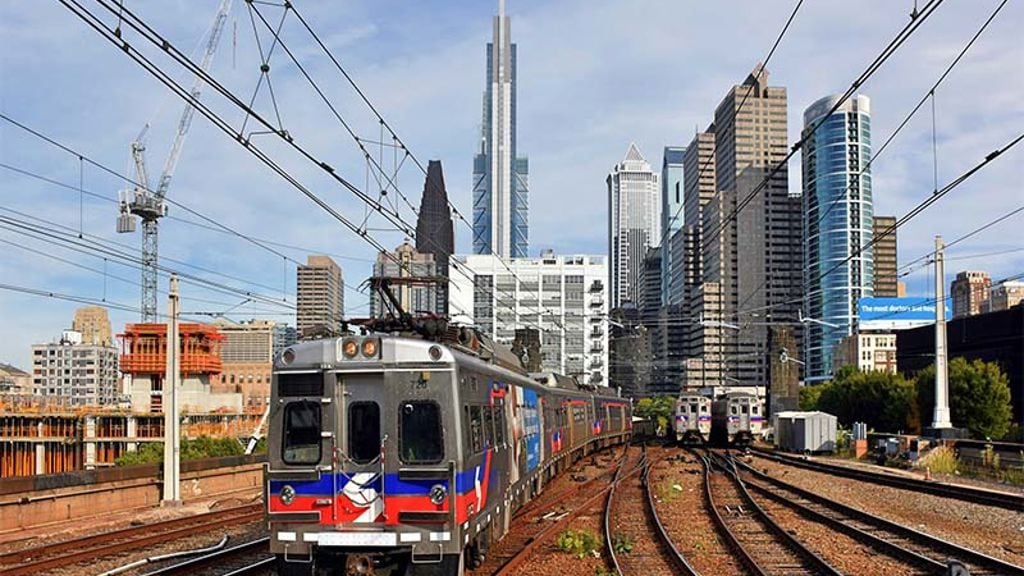 A train on the railway tracks with a skyline in the distance