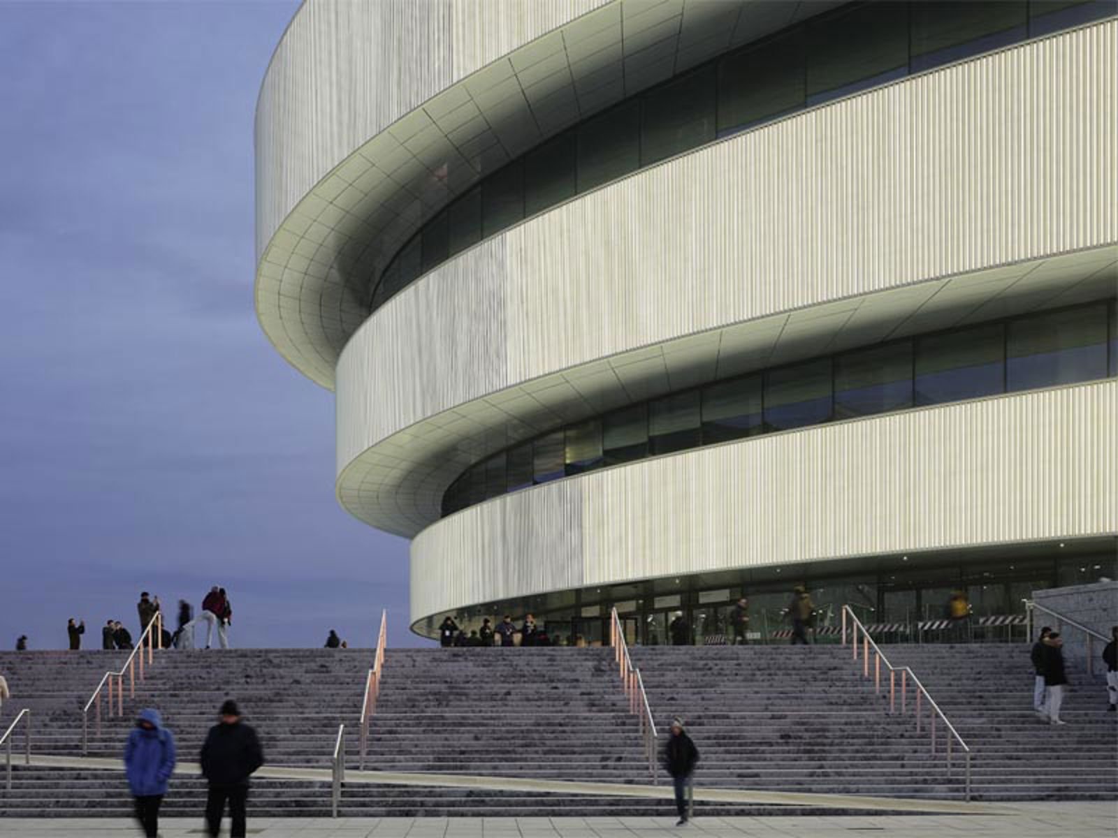 People walking up stairs to a building.