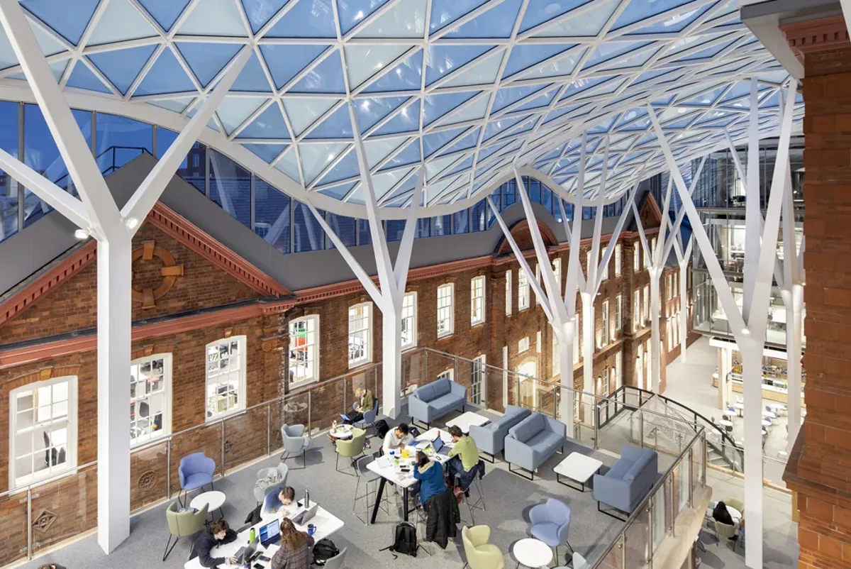 A group of people sitting at tables in a large building.