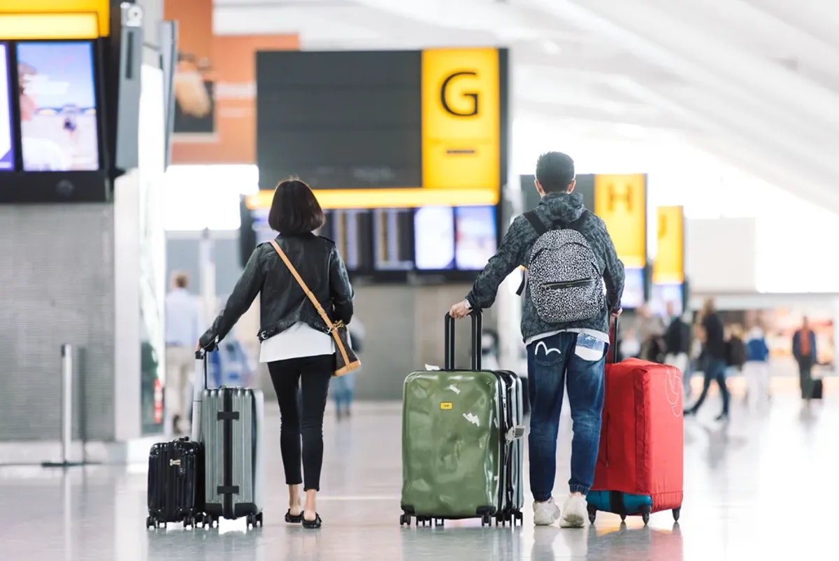 A couple of people with luggage.