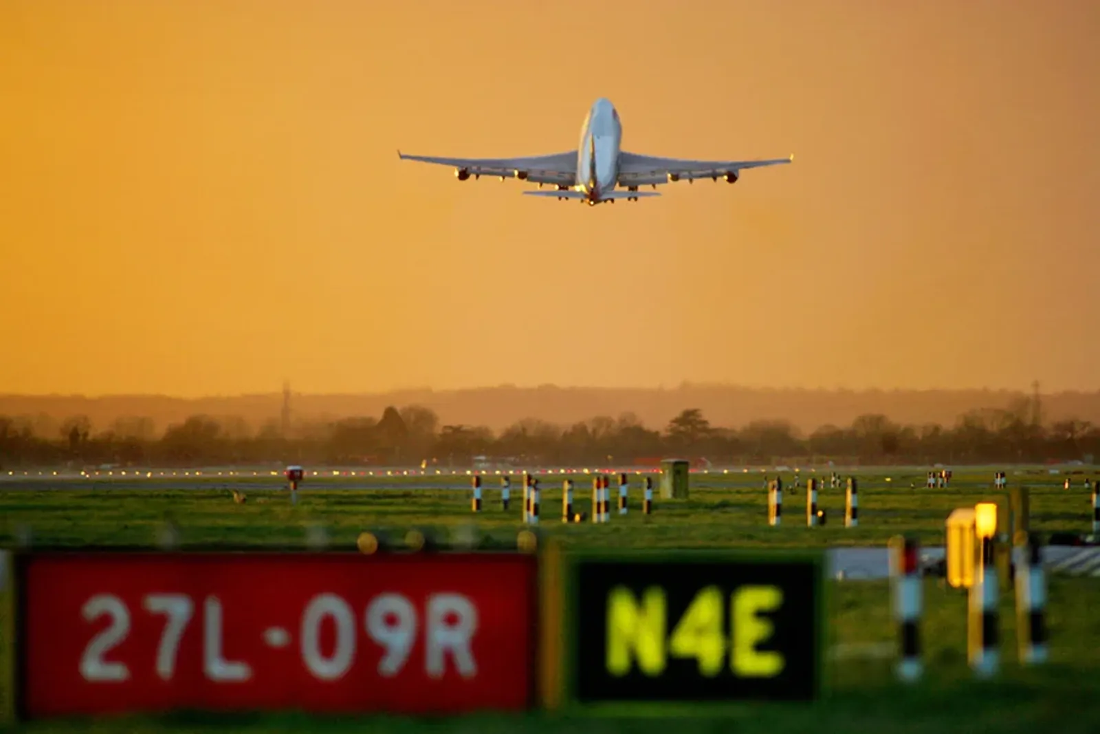 An airplane flying over a runway.