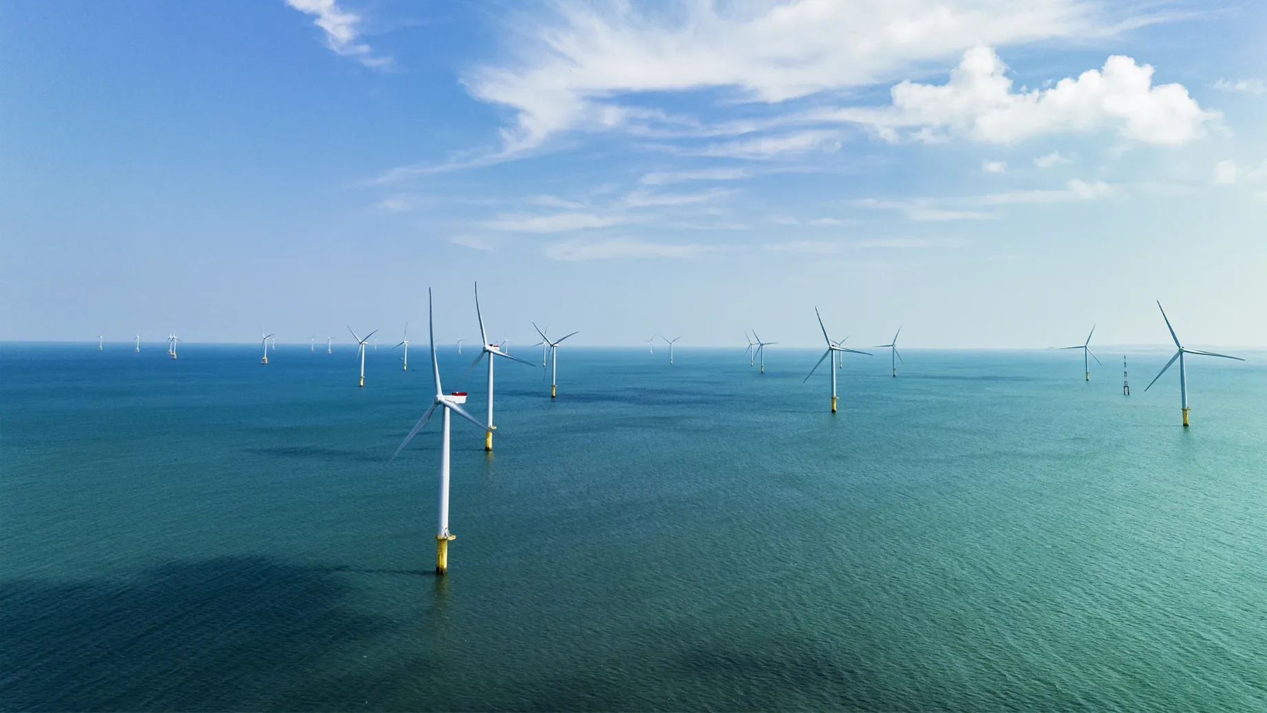 A group of wind turbines in the ocean.