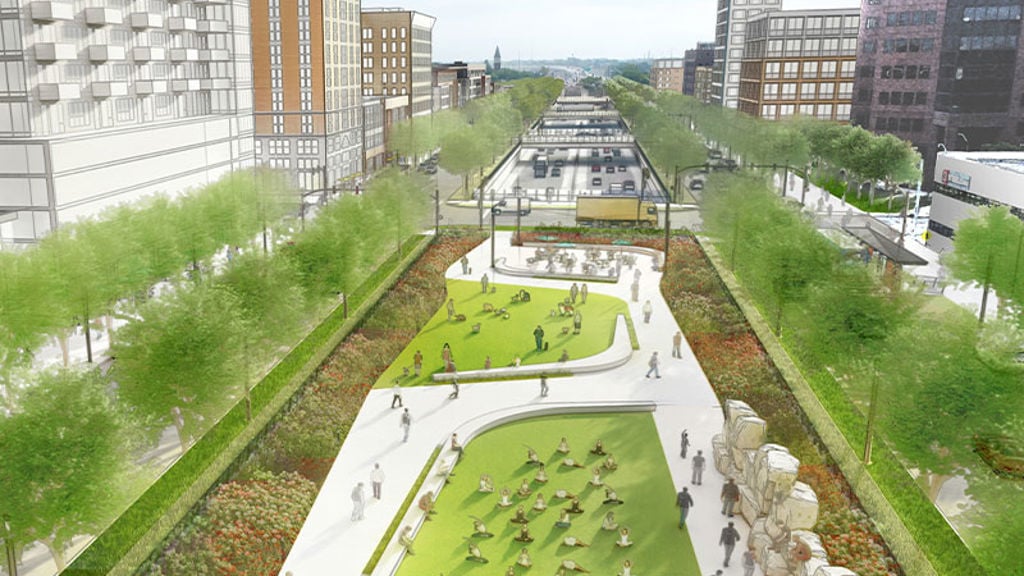 A large green space next to a recessed highway