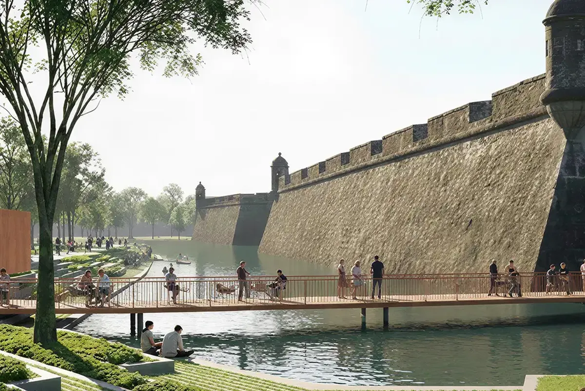 A stone wall with a moat and people walking around.