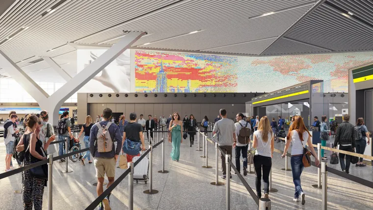 A group in line for airport security with digital display of New York City skyline above