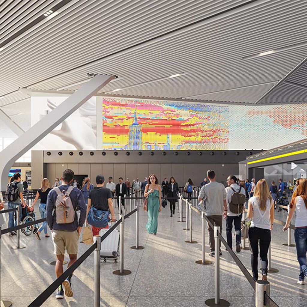 A group in line for airport security with digital display of New York City skyline above