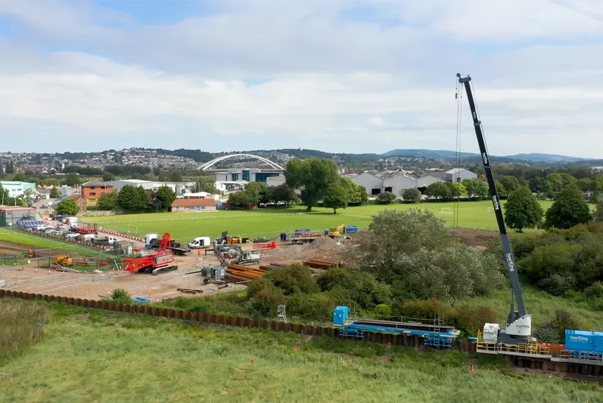 A field with a few buildings in the background.