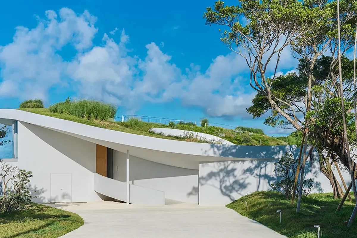 A white façade set against the vast blue sky and sea