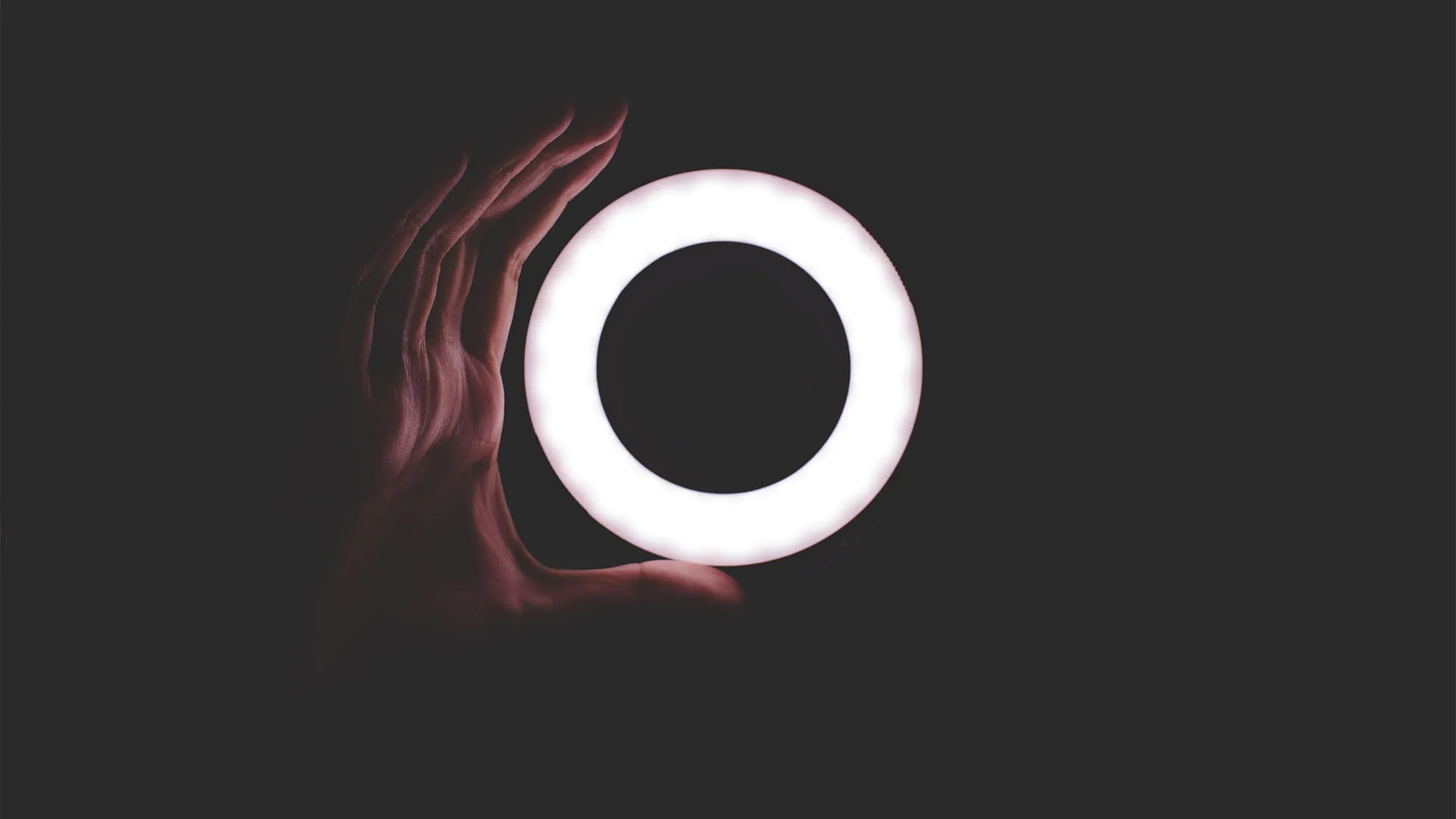 A hand holding a circular light