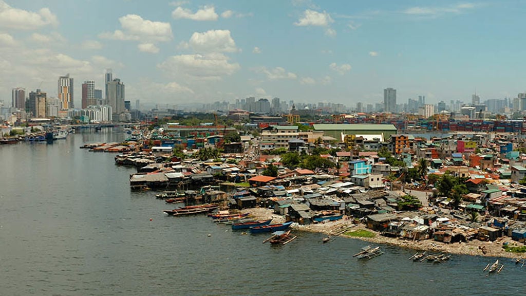 Manila’s city skyline in the distance with the Pasig River and buildings in the foreground