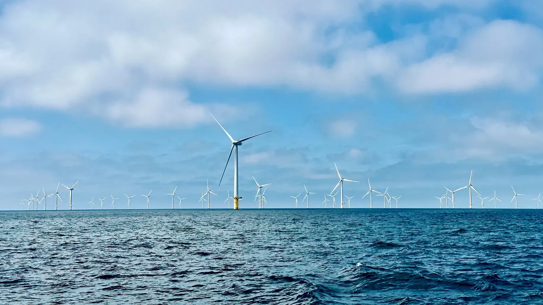 A group of wind turbines in the water.