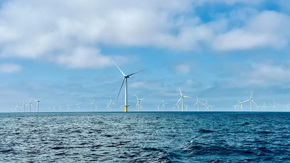 A group of wind turbines in the water.