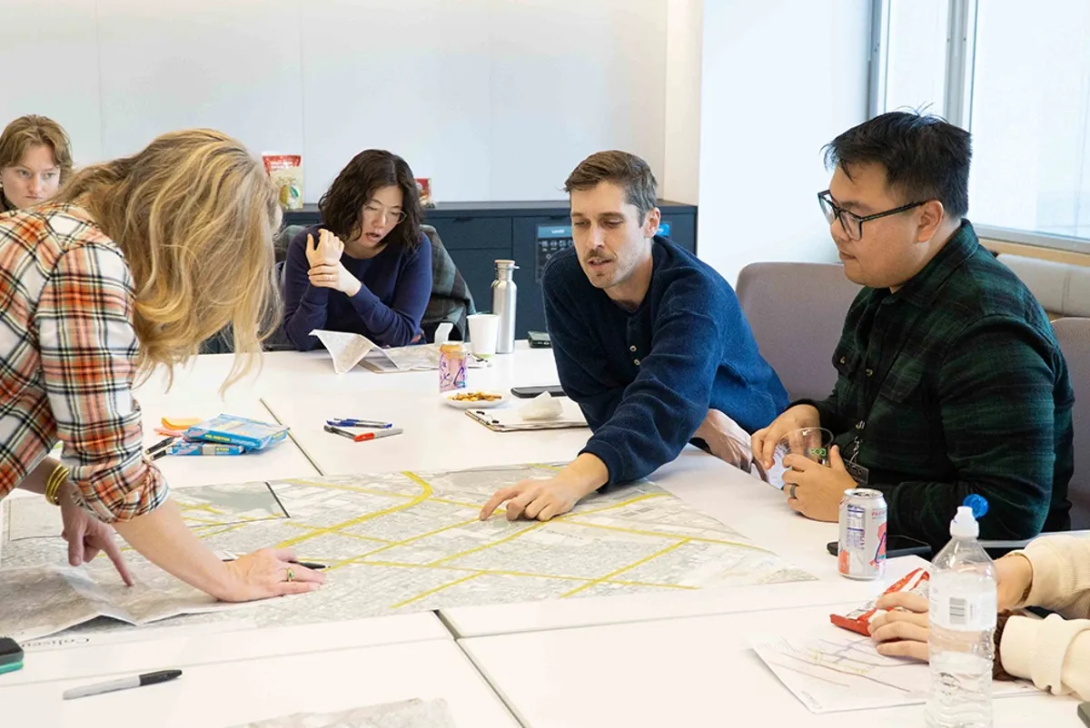 A group of people sitting around a table discussing a map