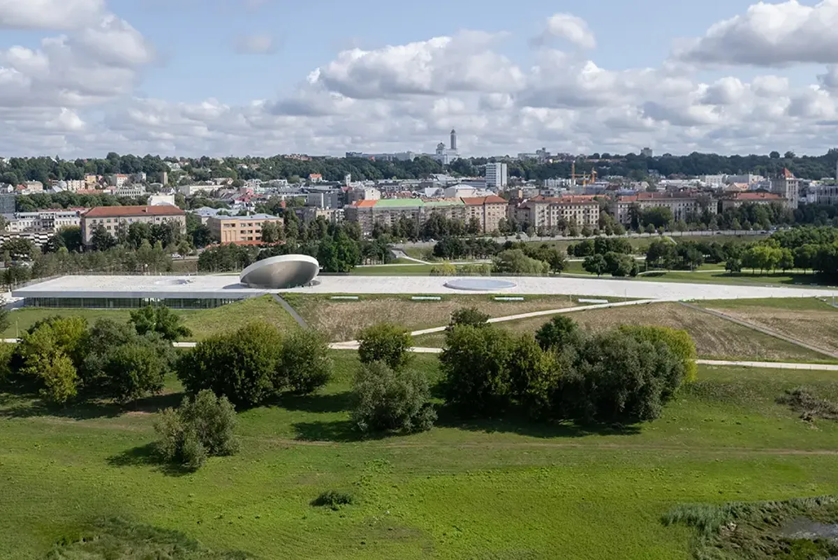 A large building with a dome on top surrounded by trees.