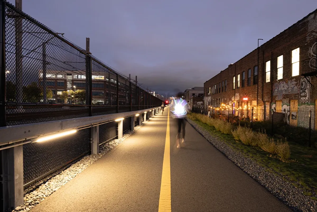 A community path at dusk with a runner