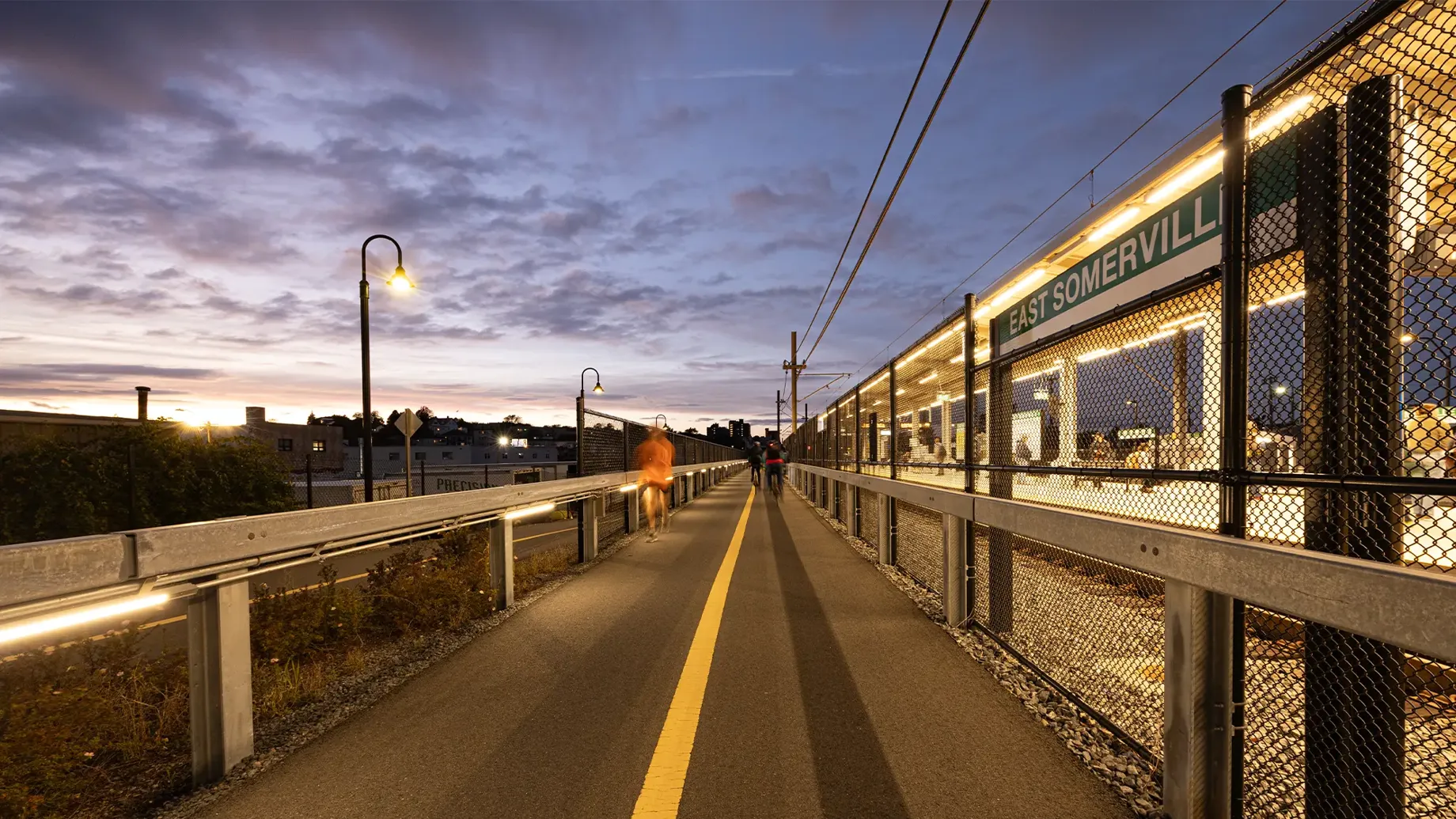 A community path next to a train station at dusk