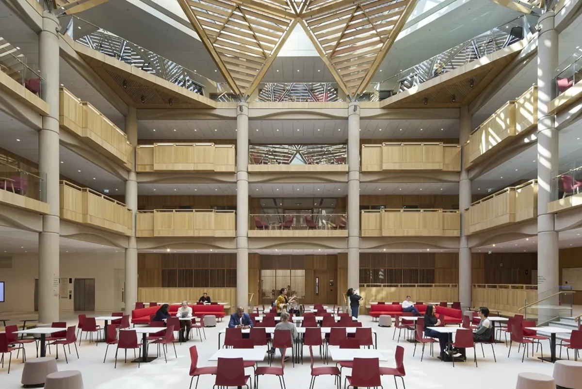 A group of people sitting at tables in a large building.