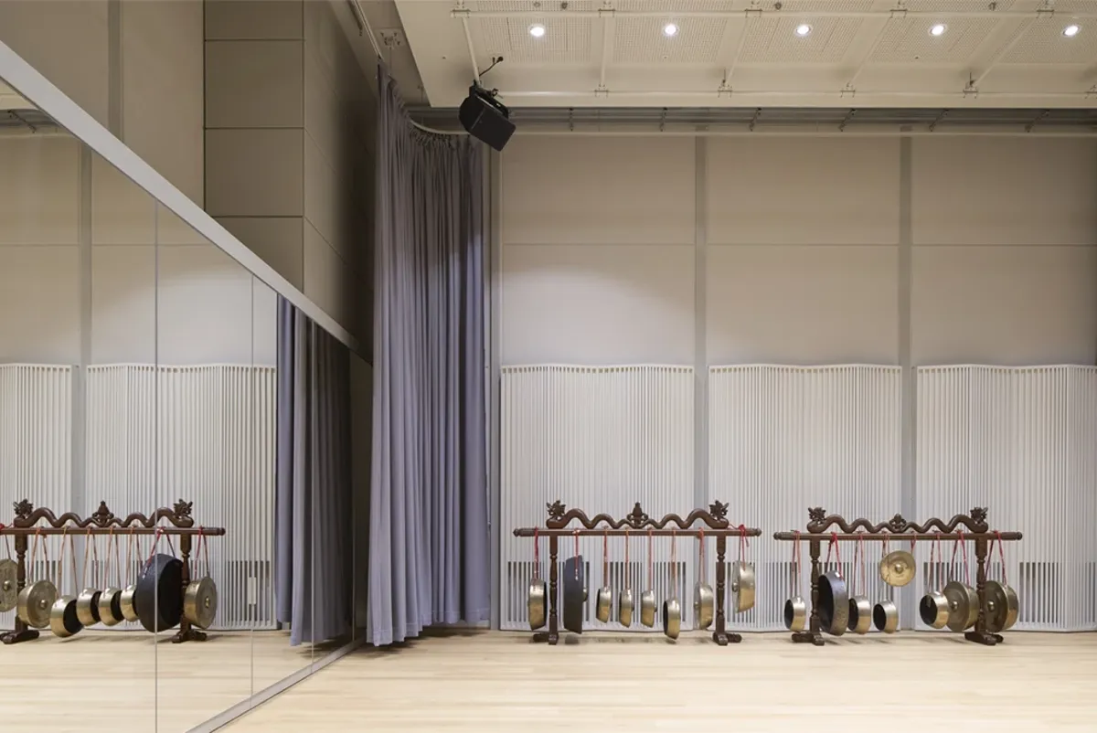 A room with a row of exercise equipment.