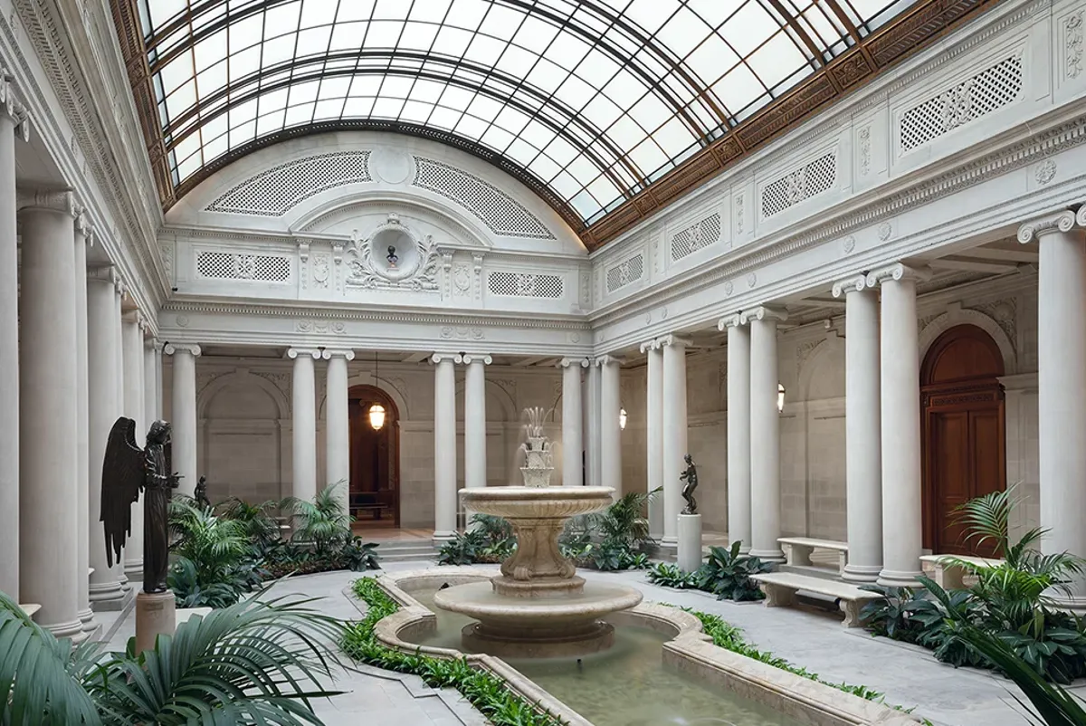 A large building with a fountain in the front.