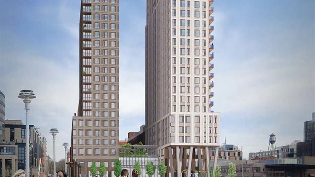 A group of people walking on a path between two tall buildings.