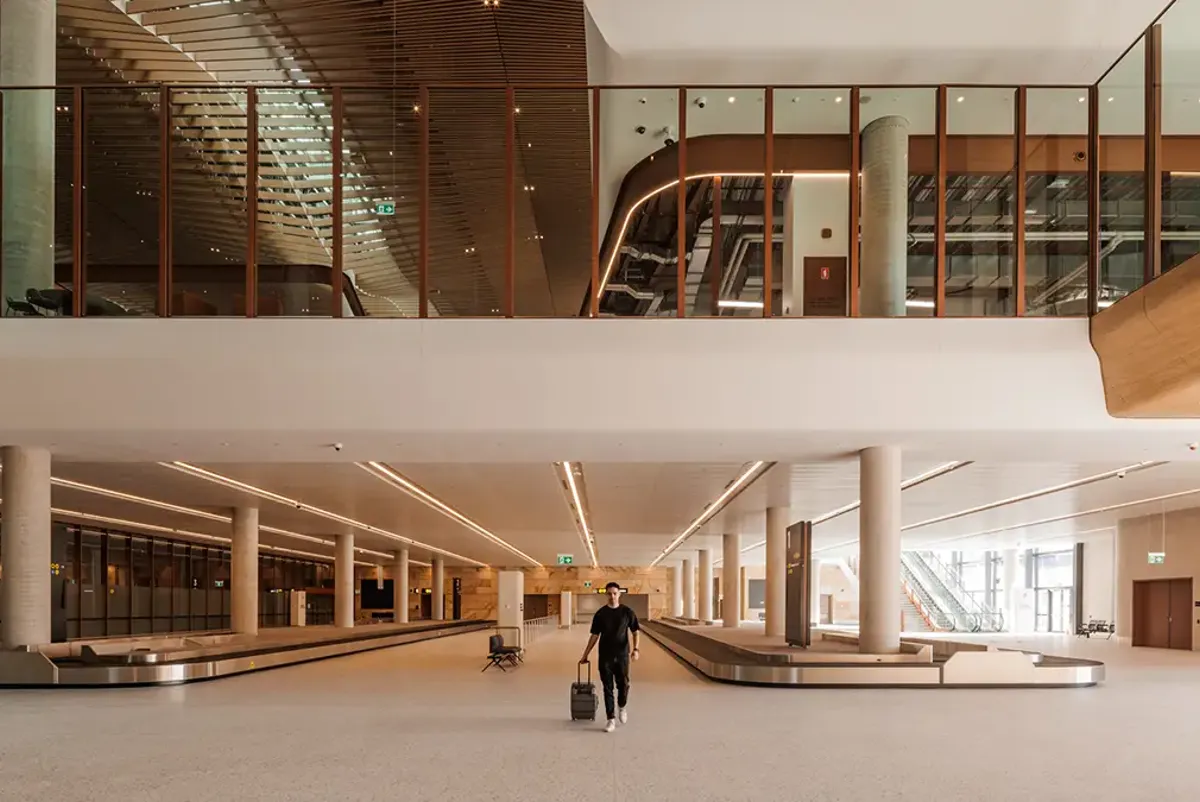 Man with suitcase at baggage carousel area in airport