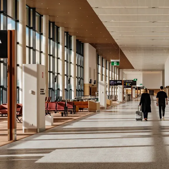 A couple of people walking past gate lounges inside Western Sydney International airport terminal